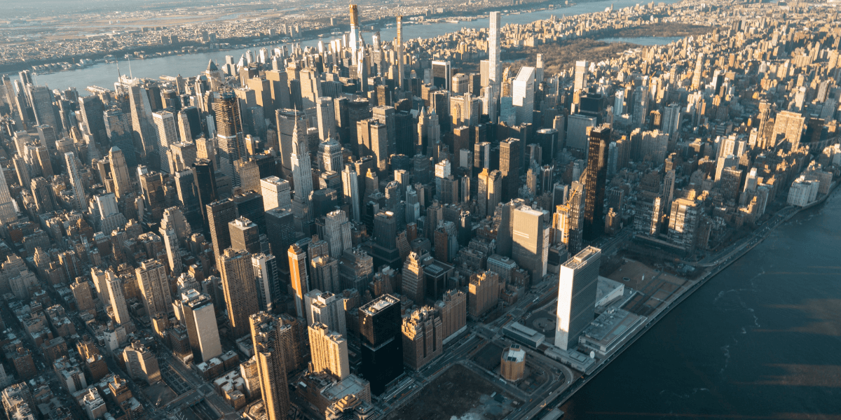 Aerial view of a dense New York City skyline with skyscrapers and river.