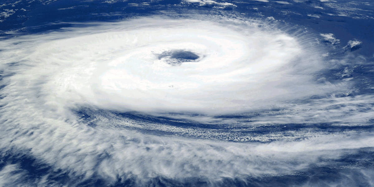 Satellite image of a swirling hurricane over the ocean with a clear eye.