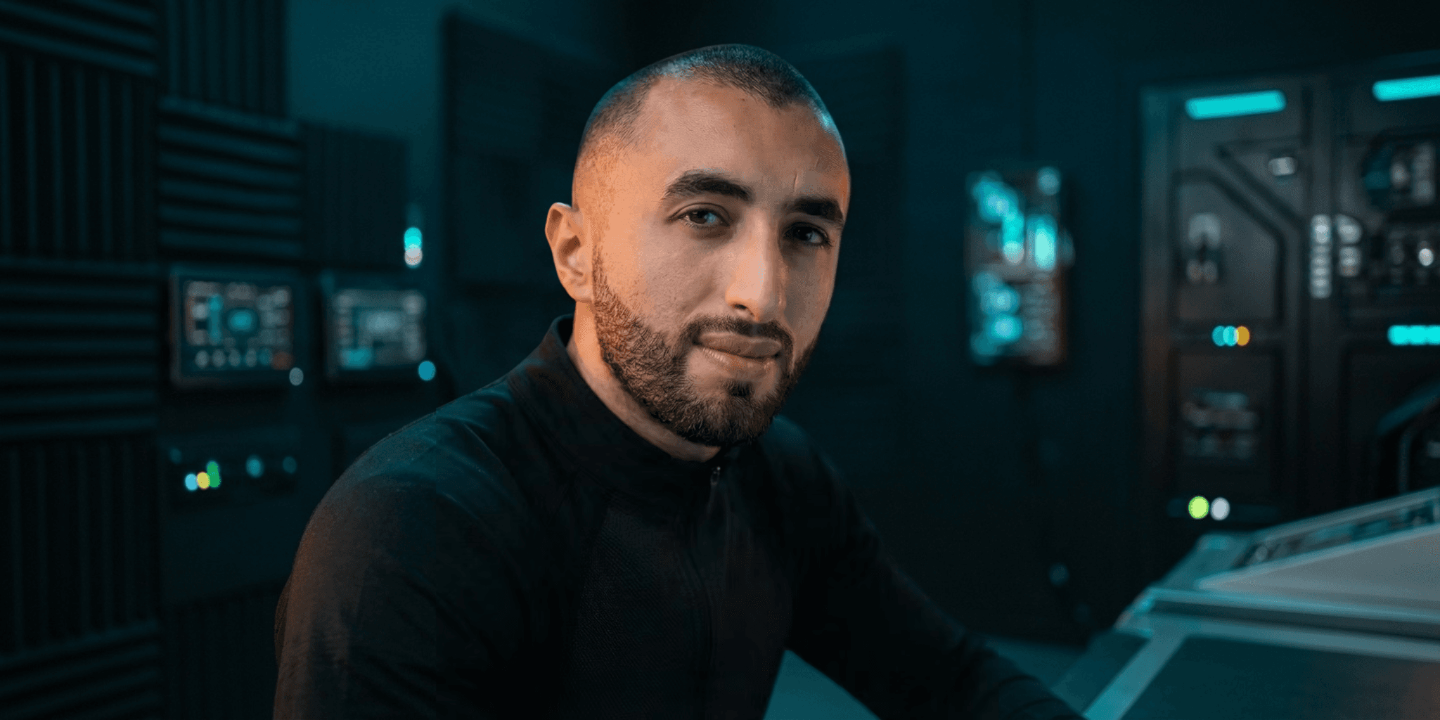 Man with a beard in a futuristic control room setting