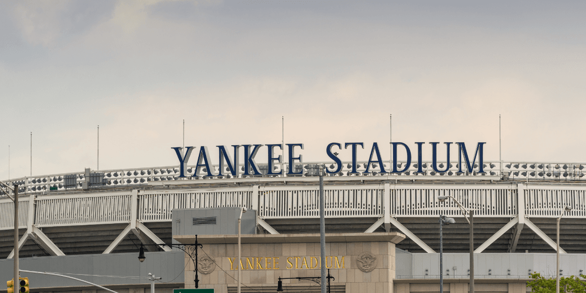 Yankee Stadium exterior with stadium signage above the entrance under an overcast sky.