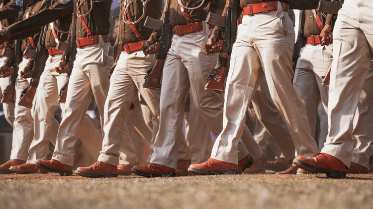 Soldiers in uniform marching in formation, showcasing polished boots and rifles.