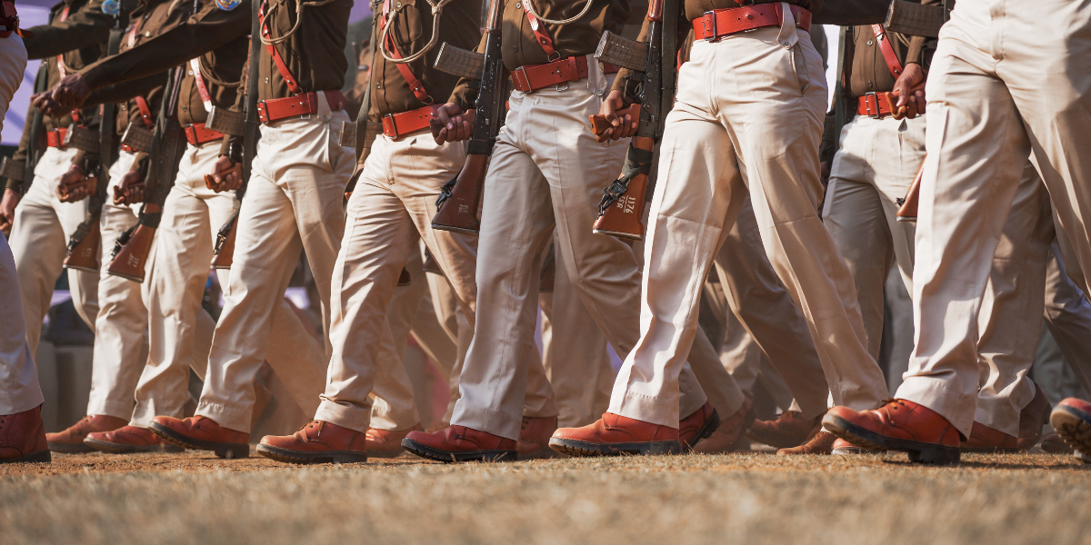 Soldiers in uniform marching in formation, showcasing polished boots and rifles.