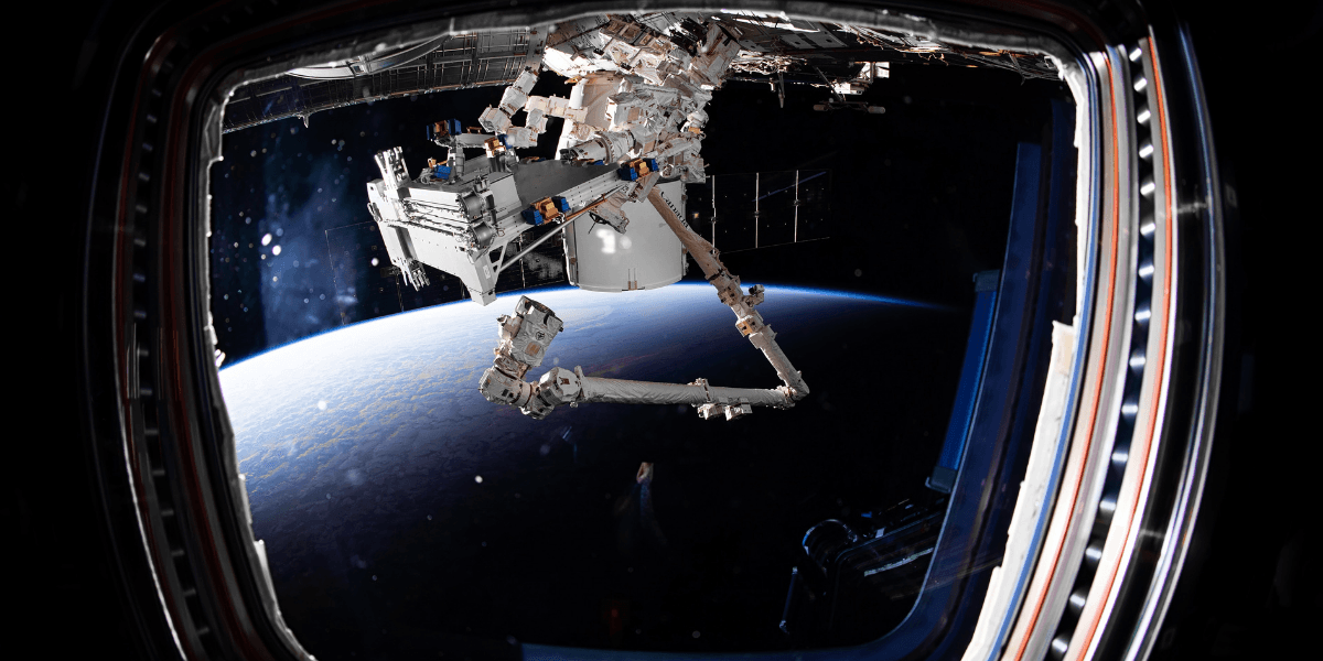 View of Earth from the International Space Station with robotic arm extending outside