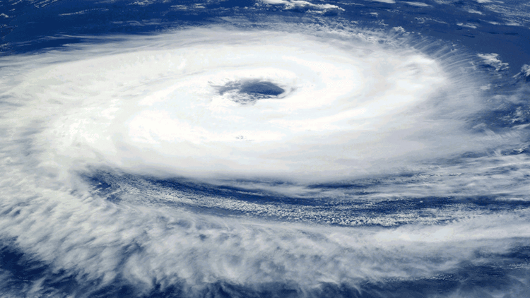 Satellite image of a swirling hurricane over the ocean with a clear eye.