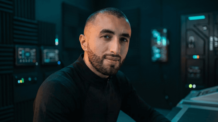 Man with a beard in a futuristic control room setting