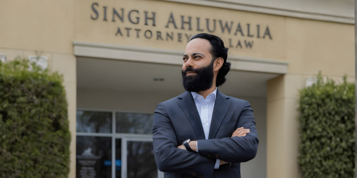 Deepak Ahluwalia, attorney at Singh Ahluwalia Law, confidently stands in front of the firm's office, showcasing professionalism and dedication.