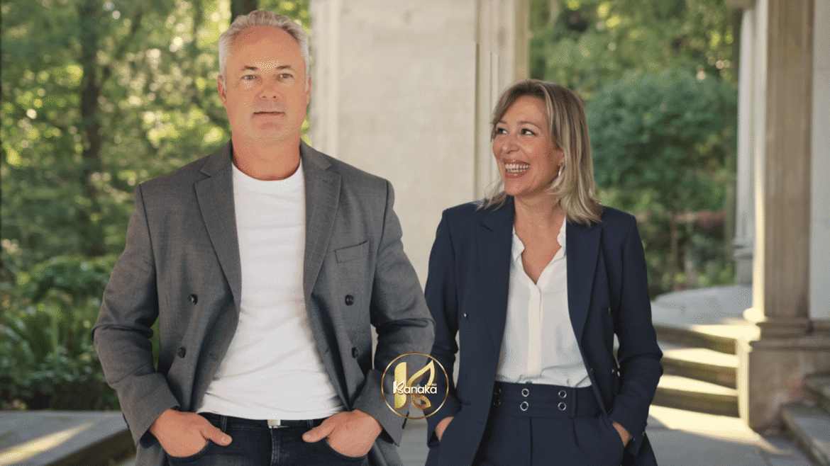 A professional man and woman smiling while walking outdoors, dressed in business attire.