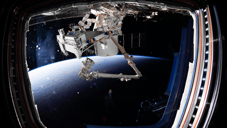 View of Earth from the International Space Station with robotic arm extending outside